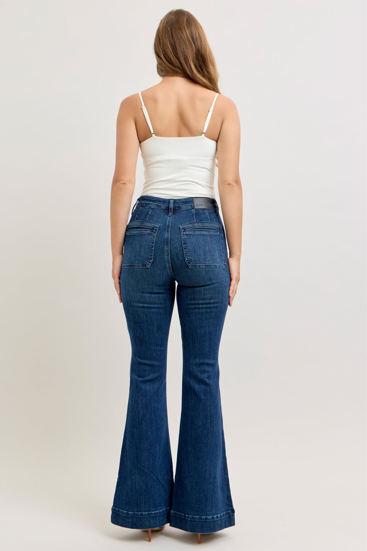 Judy Blue high waist pintuck flare jean in dark wash, side view showing the flare