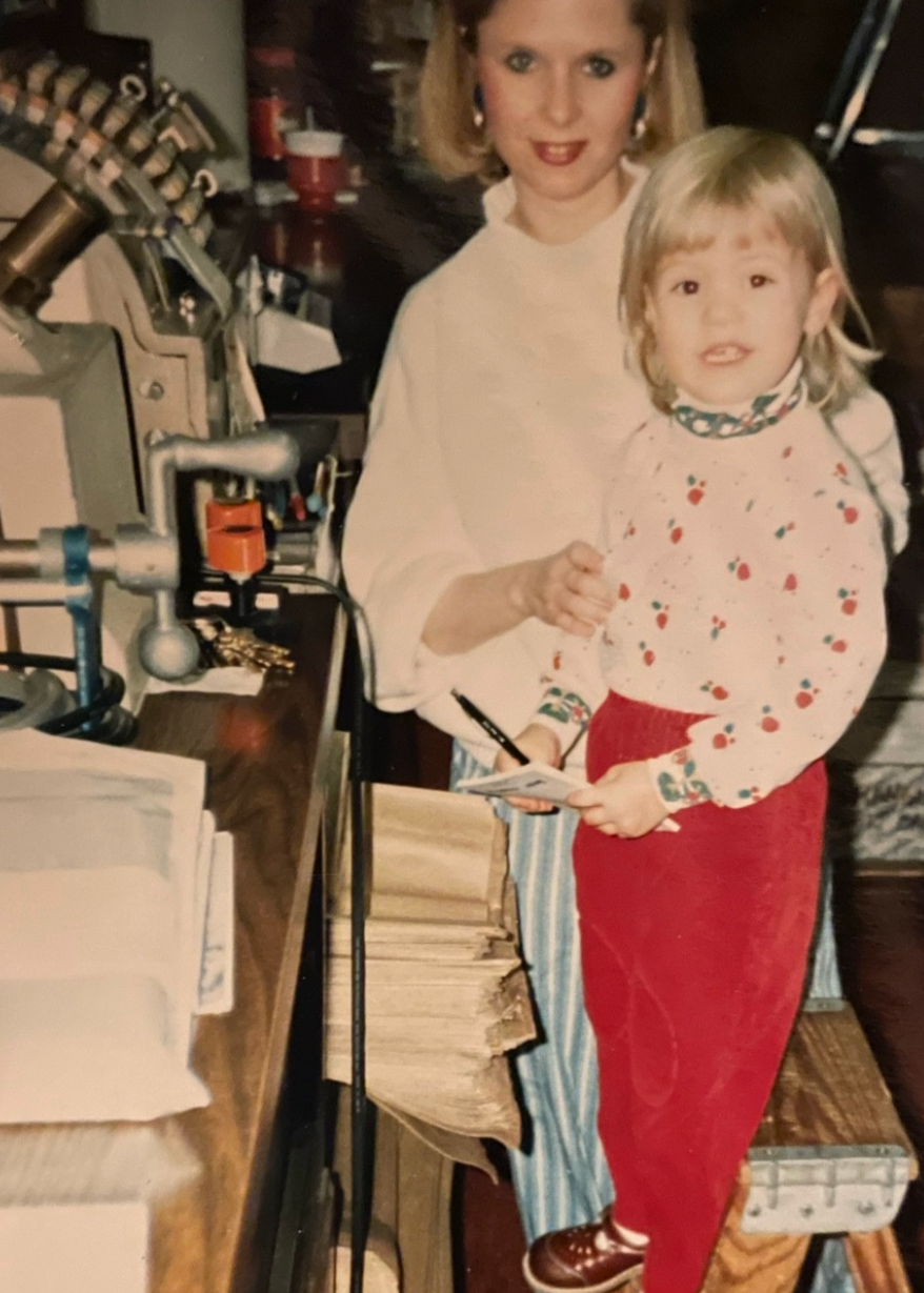 Young Katie with her mother at the store counter