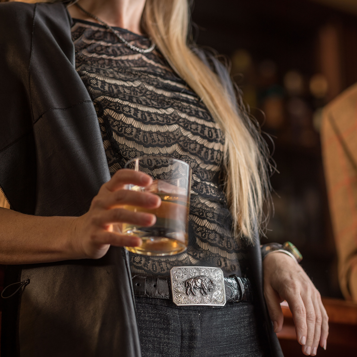 Woman in a western jacket wearing the Clint Orms Jasper 1800 sterling silver buffalo buckle