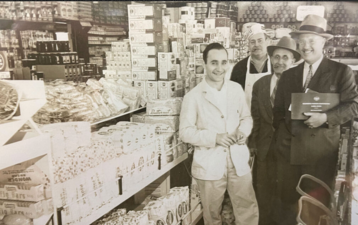 Old photo of men standing in the aisles of the Nigro's grocery store