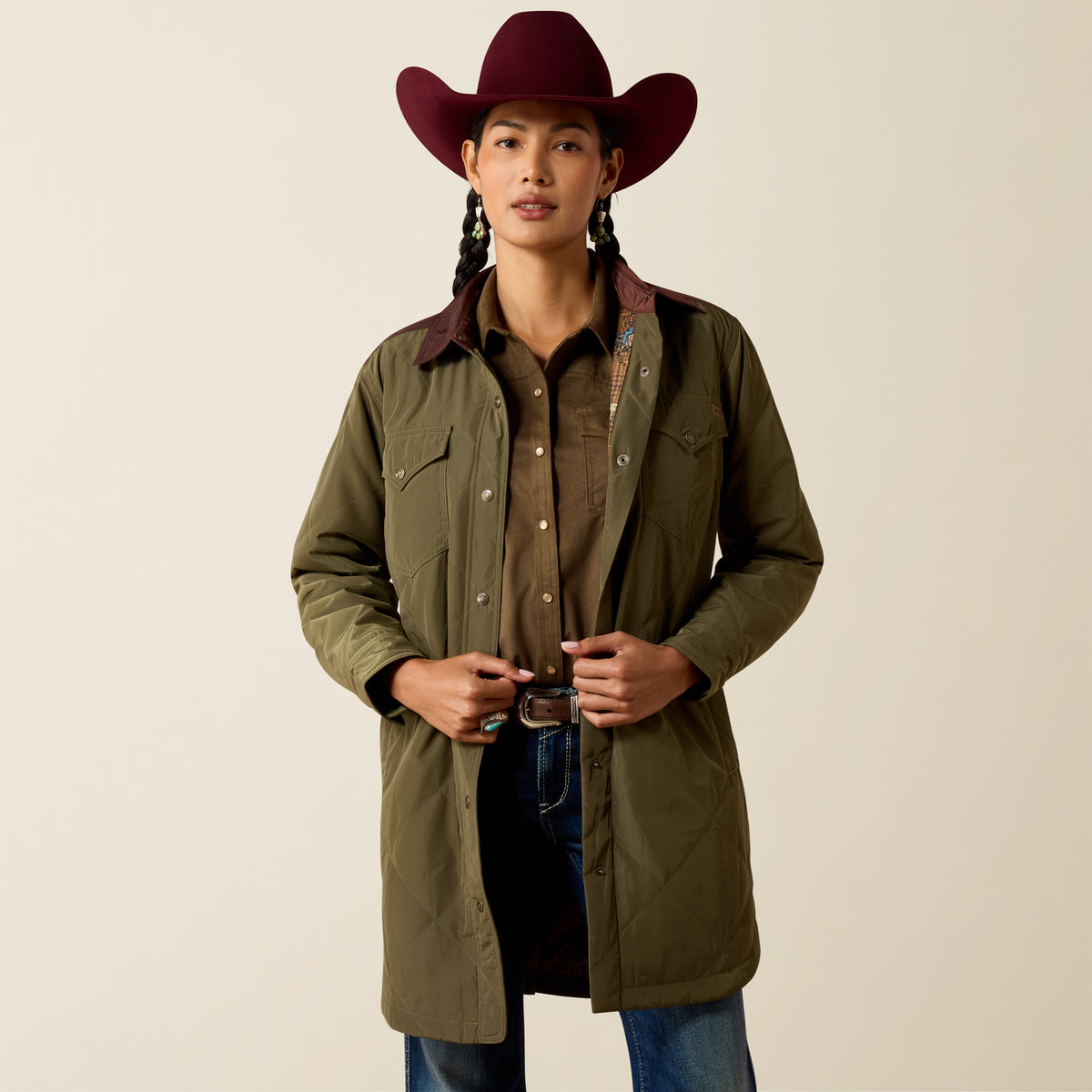 Ariat Women's Dilon Parka Jacket in Ivy Green and Chicory Coffee, shown on a model in a natural outdoor setting.