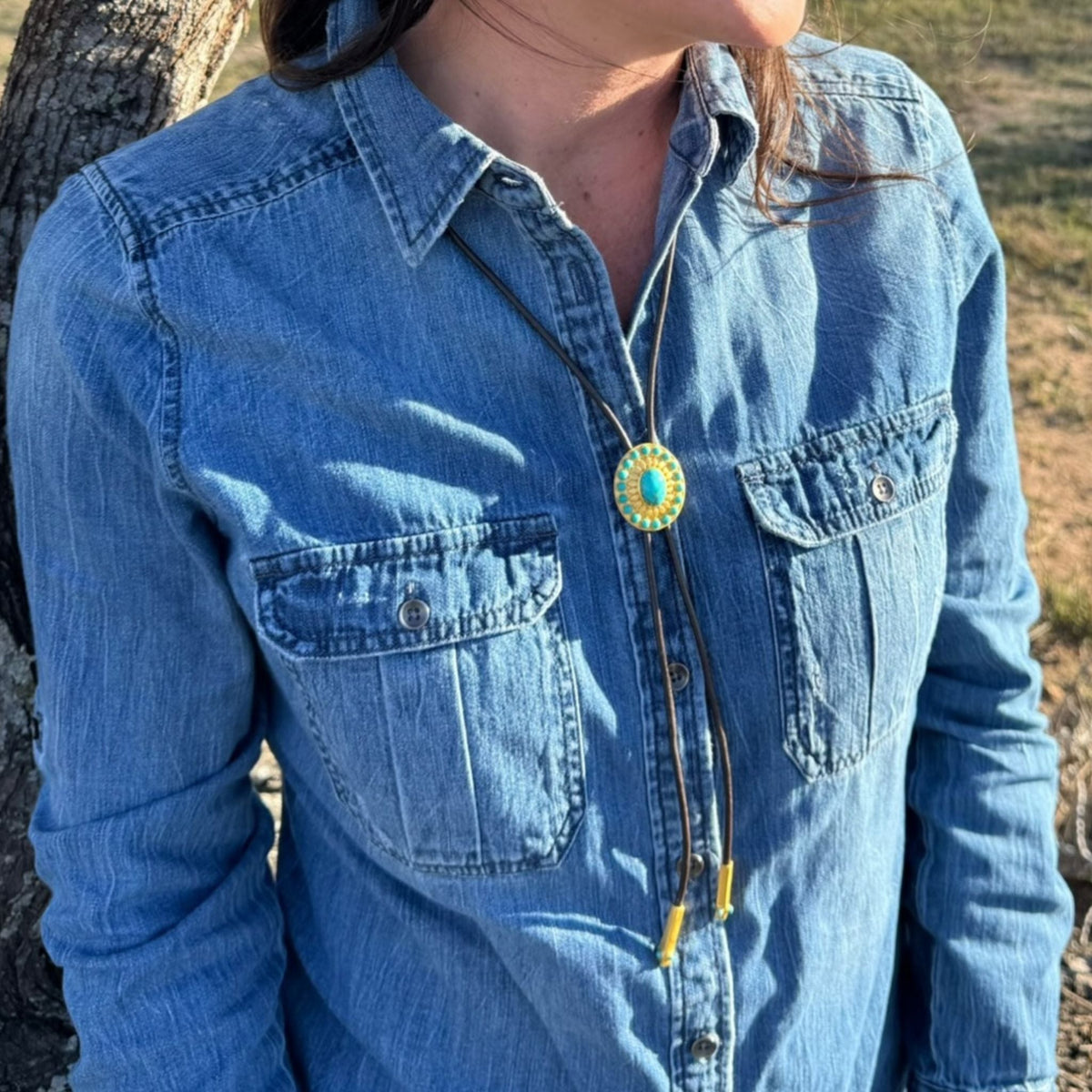 Christina Greene Canyon Sky Turquoise Bolo Tie featuring a turquoise stone centerpiece and leather cord with silver accents.