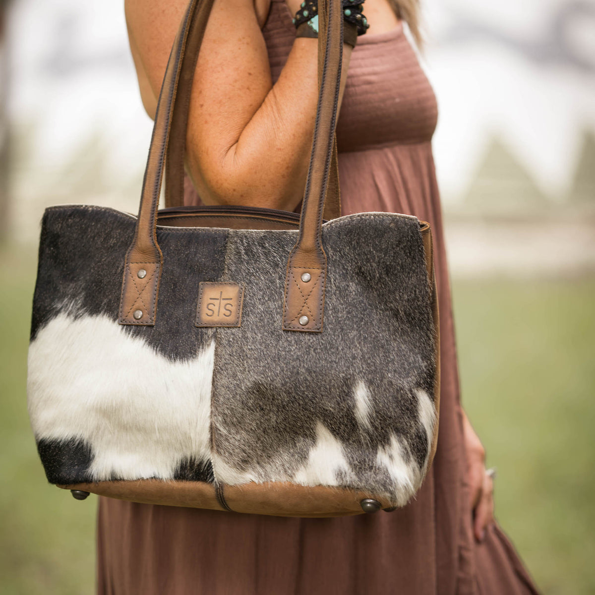 Cowhide Josie Tote by STS Ranchwear featuring a stylish, textured leather and cowhide design with sturdy handles.