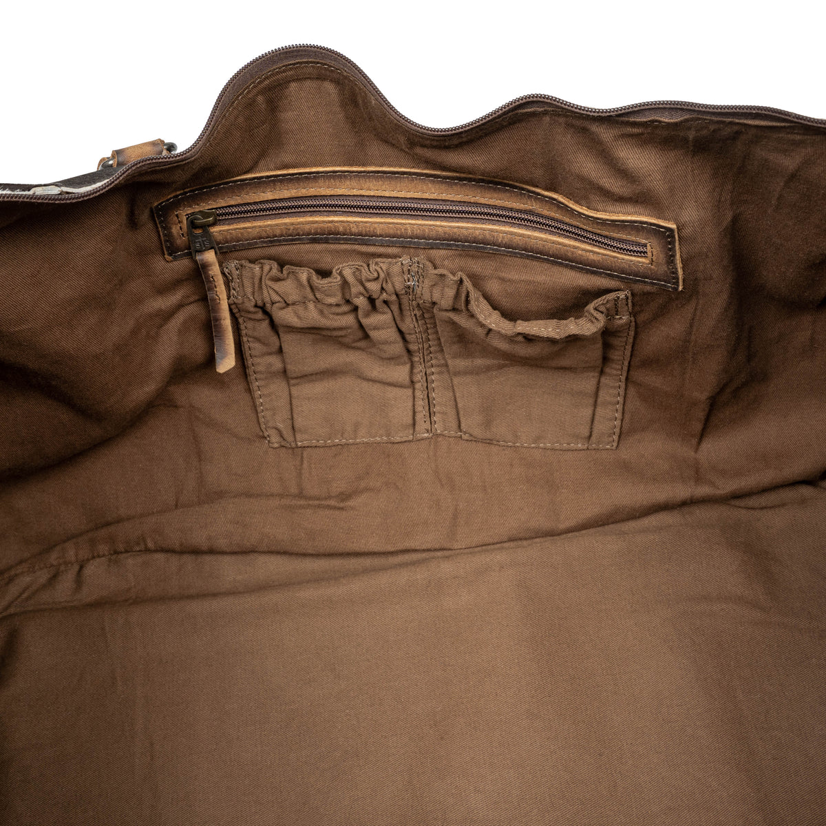 Brown cowhide Rustler Duffle bag from STS Ranchwear with leather accents and sturdy handles, designed for rugged travel.