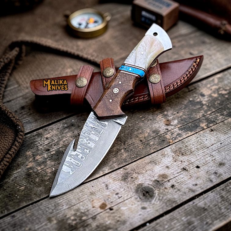 Malika Knives Damascus gut hook hunting knife with wood handle and sheath, featuring a sleek Damascus blade for outdoor use.