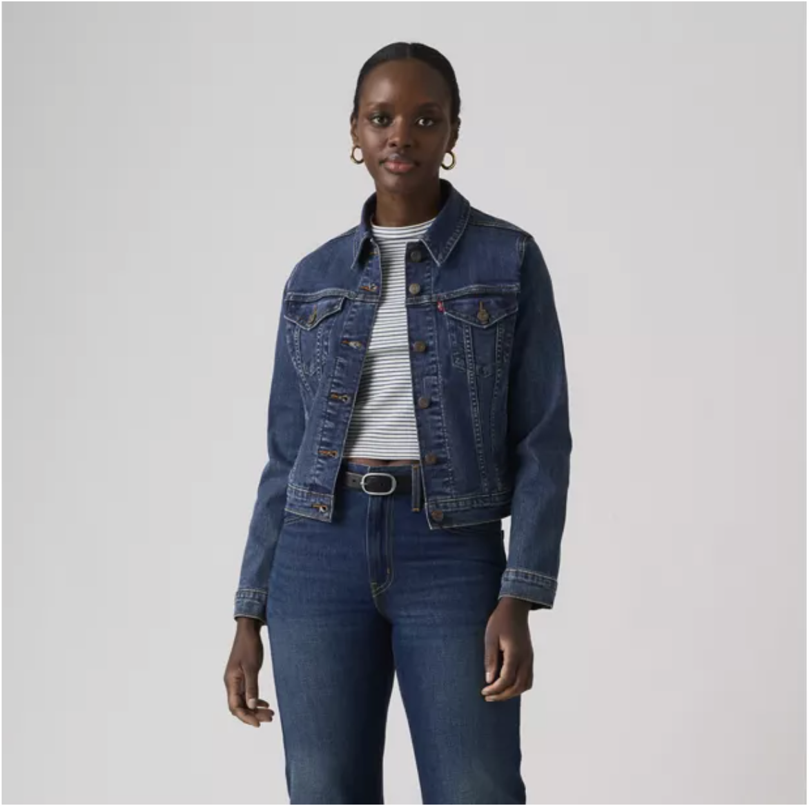 Levi's® women's blue original trucker jacket displayed on a hanger, showcasing classic denim style and button-front design.