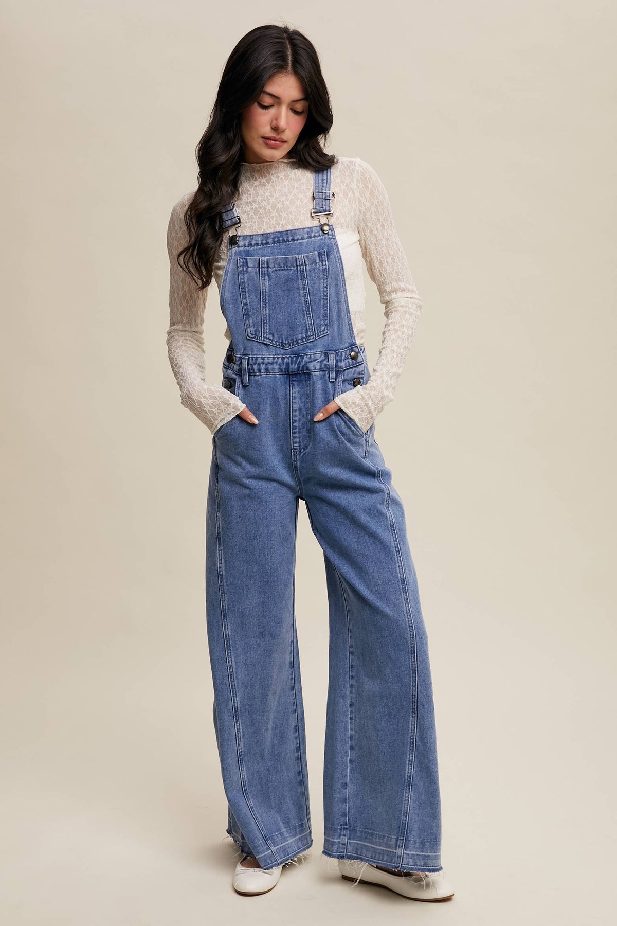 Wide-leg denim overalls by Listicle featuring adjustable straps, front pockets, and a relaxed fit in classic blue denim.
