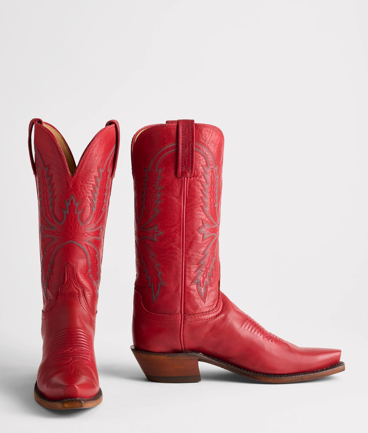 Red Lucchese Savannah cowboy boot with intricate stitching and pointed toe, crafted from high-quality leather.