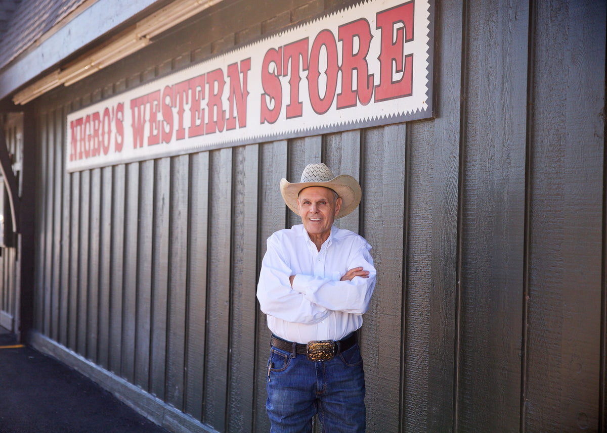 George Nigro in front of the Nigro's Western Store sign