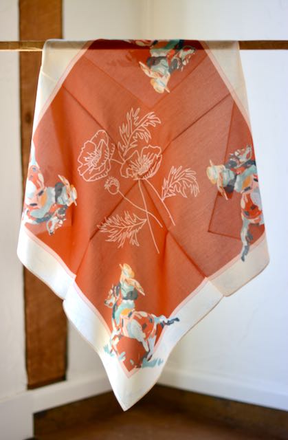 Poppy Cowgirl Western scarf bandana made of silk and Tencel with a vibrant poppy floral design, styled as a wild rag.