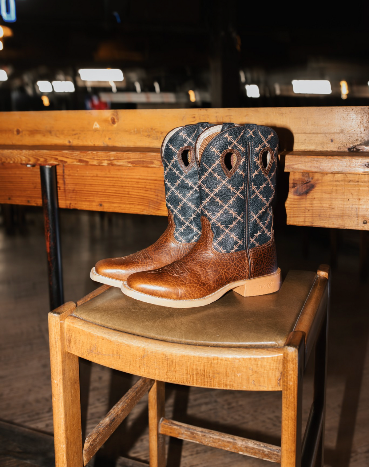 Twisted X Men's 12-inch Tech X™ boots in rustic brown and navy with rugged leather design and sturdy sole.