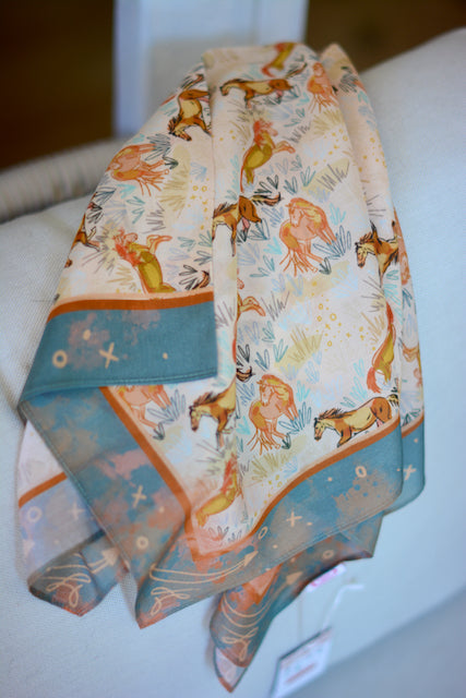 Tirzah Lane Art silk scarf featuring wild horses running through a meadow with vibrant colors and detailed horse illustrations.