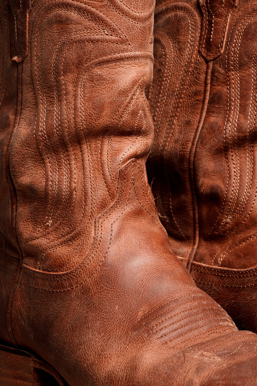 Close-up of a broken-in brown leather cowboy boot at Nigro's Western Store in Shawnee, Kansas