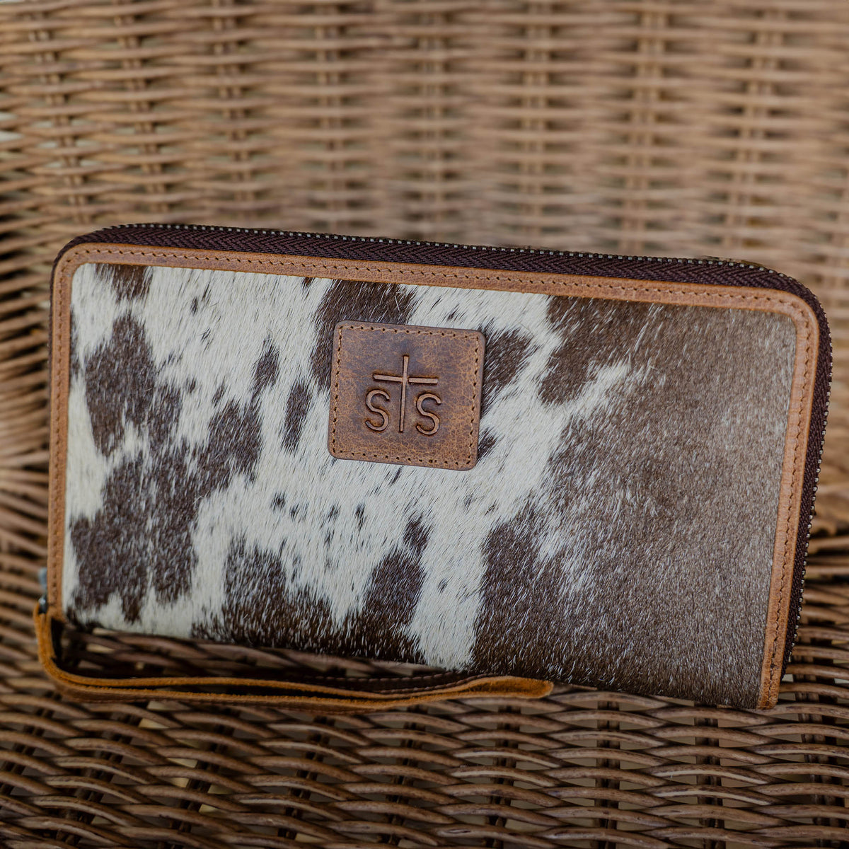 STS Ranchwear Women's Vaquero Cowhide Concho Bentley Wallet, Brown and White Hair-On – lifestyle on wicker chair