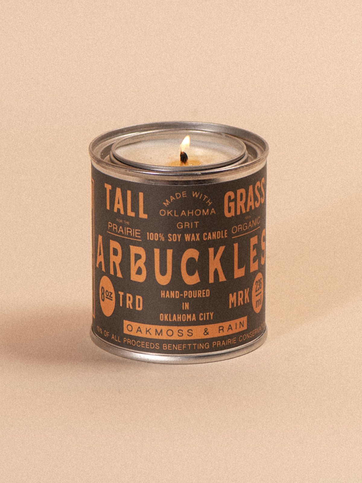 Tallgrass Supply Arbuckles soy wax candle with oakmoss and rain fragrance, featuring a tall, elegant candle design.