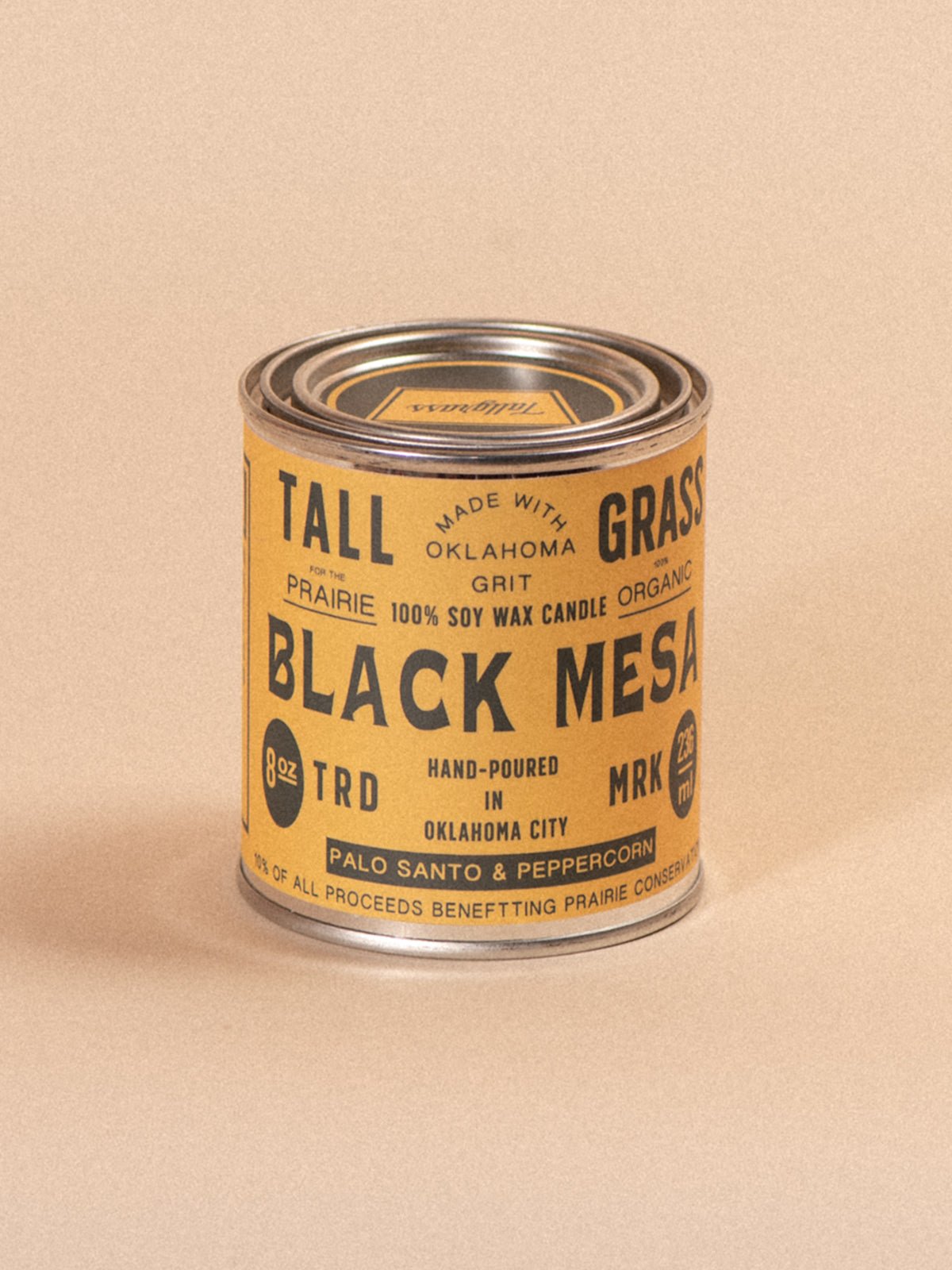 Tallgrass Supply Black Mesa Palo Santo and Peppercorn soy wax candle with black and white packaging and a lit wick.