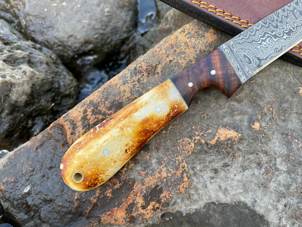 Titan International K bonning and flaying knife with high-carbon ladder Damascus blade, designed for butchering and skinning.
