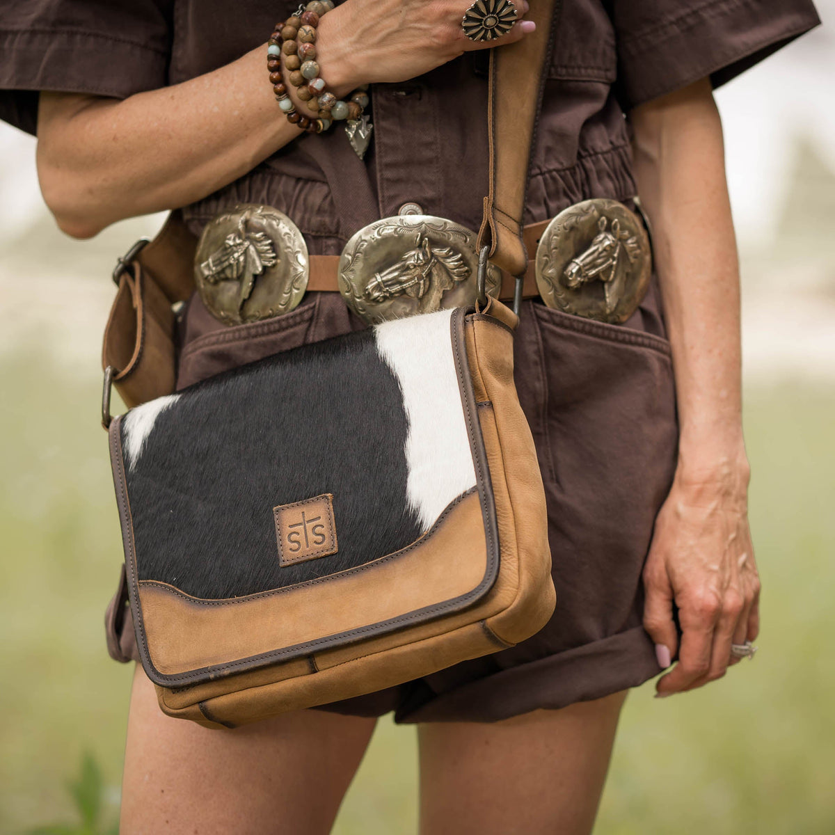 STS Ranchwear Cowhide Della Crossbody bag with adjustable strap and rustic leather finish, ideal for casual or outdoor use.