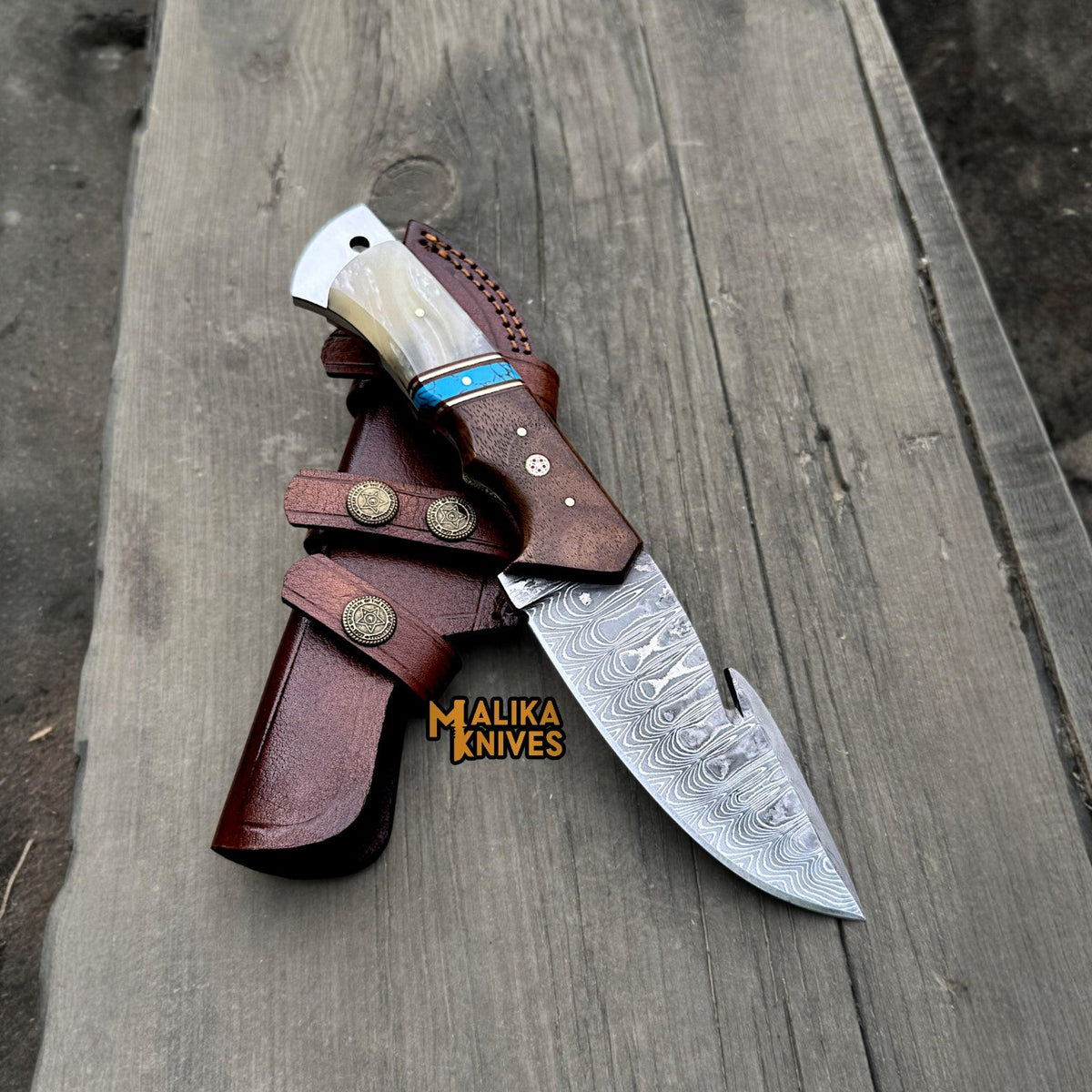 Malika Knives Damascus gut hook hunting knife with wood handle and sheath, showcasing a sleek, durable outdoor hunting tool.