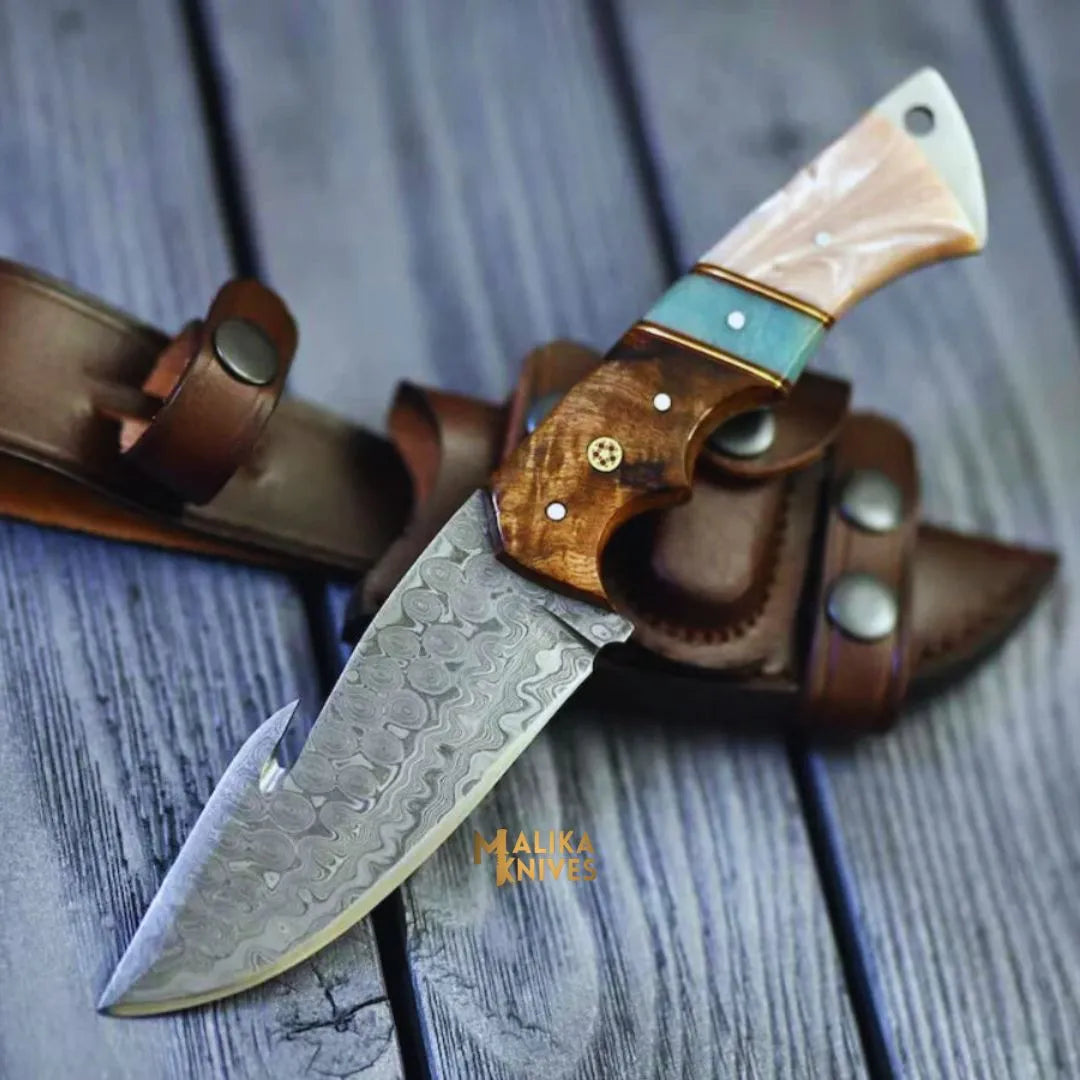 Malika Knives Damascus Gut Hook Hunting Knife with wood and resin handle, showcasing a sleek, simple design for outdoor hunting tasks.