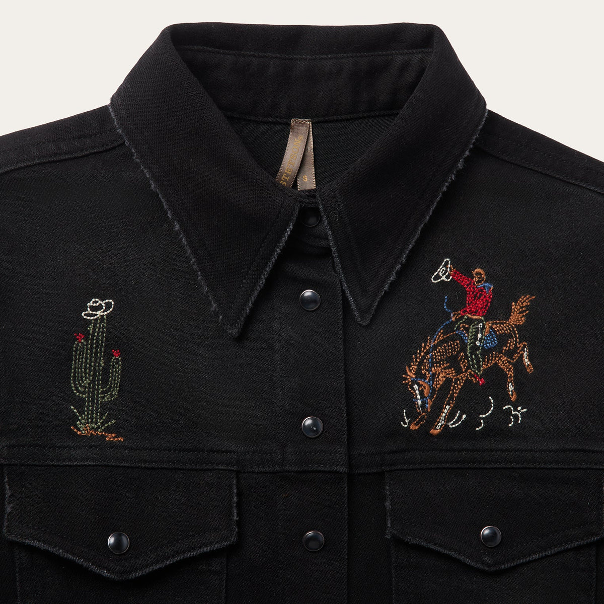 Stetson black denim shirt with intricate embroidery, featuring a classic collar and button front, displayed on a hanger.