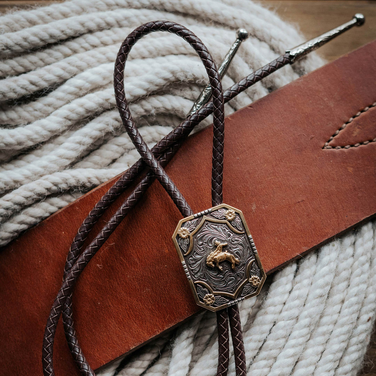 AndWest Iconic Bronc Rider Bolo Tie featuring detailed cowboy and horse design on a leather cord for Western style.