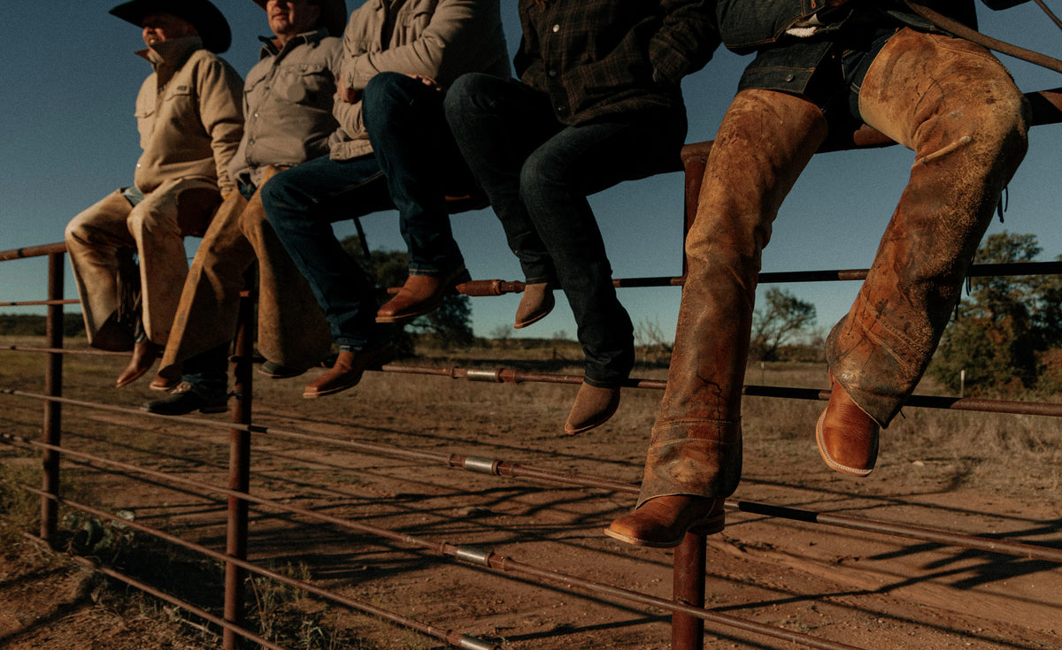 Justin Bent Rail boots propped on a corral fence