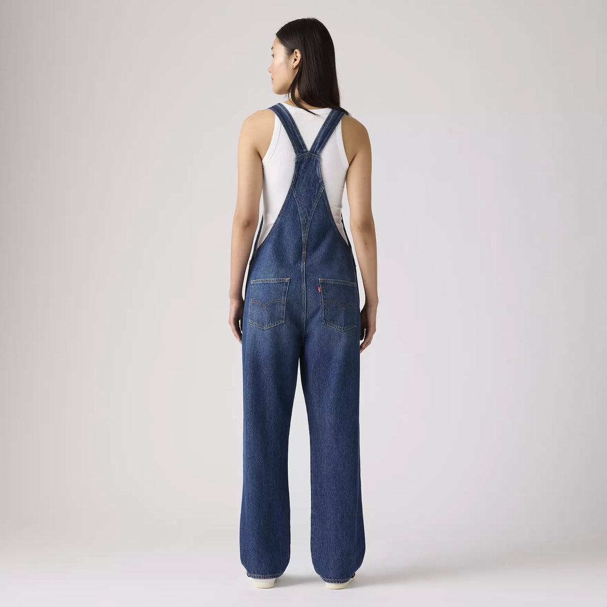 Levi's Women's vintage denim overalls in dark wash with adjustable straps and front pockets, styled casually.