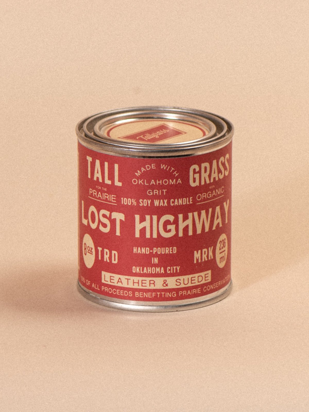 Tallgrass Supply Lost Highway soy wax candle with leather and suede scent, shown in a glass jar with a wooden lid.