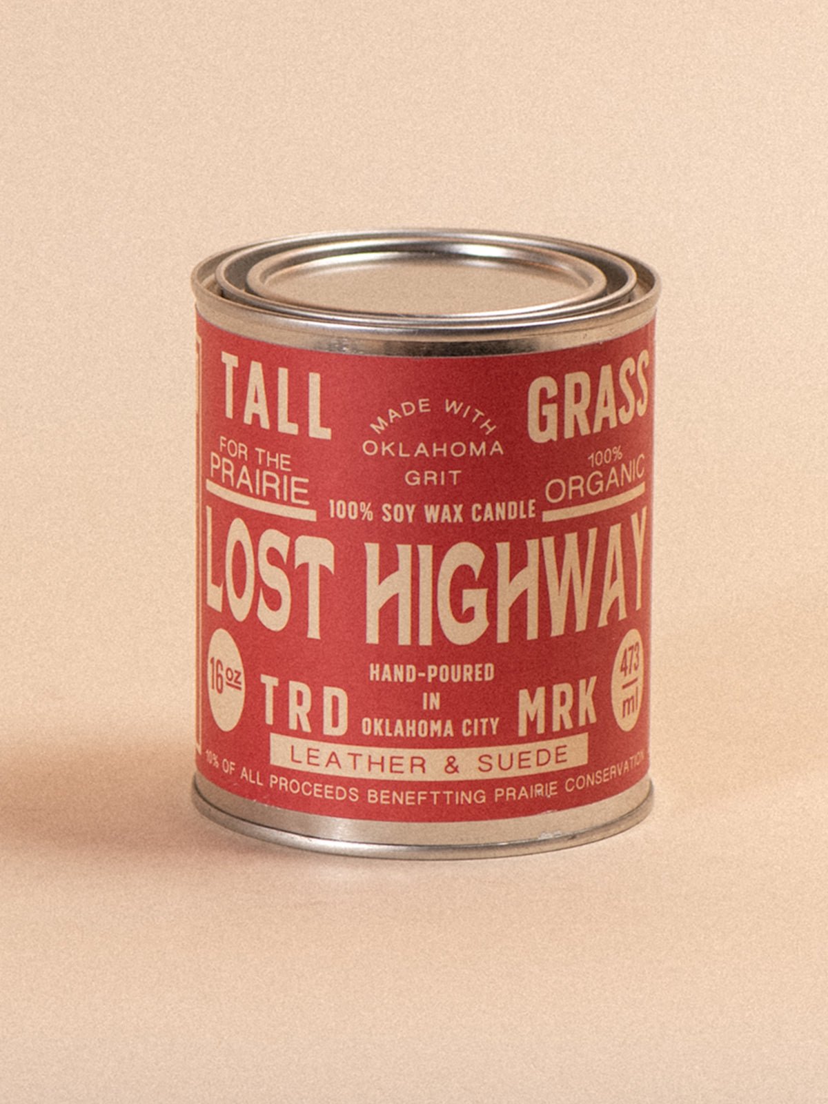 Tallgrass Supply Lost Highway leather and suede soy wax candle with a rustic glass container and natural wooden lid.