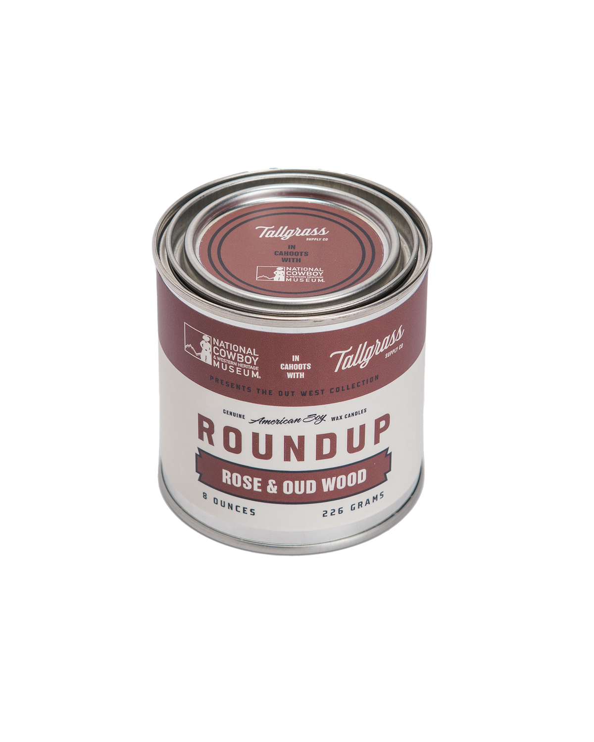 Tallgrass Supply Roundup Rose and Oud Wood soy wax candle with a white ceramic container and a burning wick.