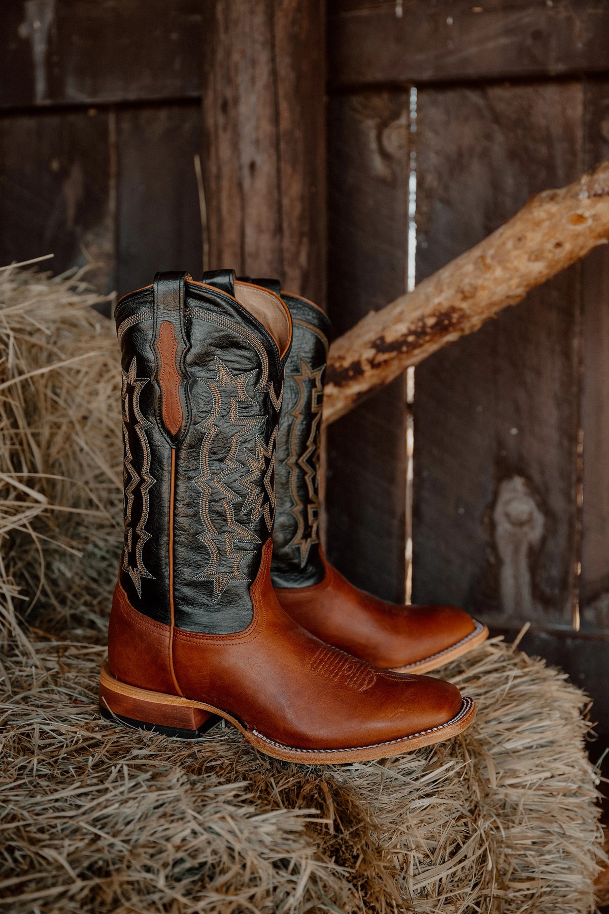 Tony Lama Heritage men's boot on hay against weathered barn wood