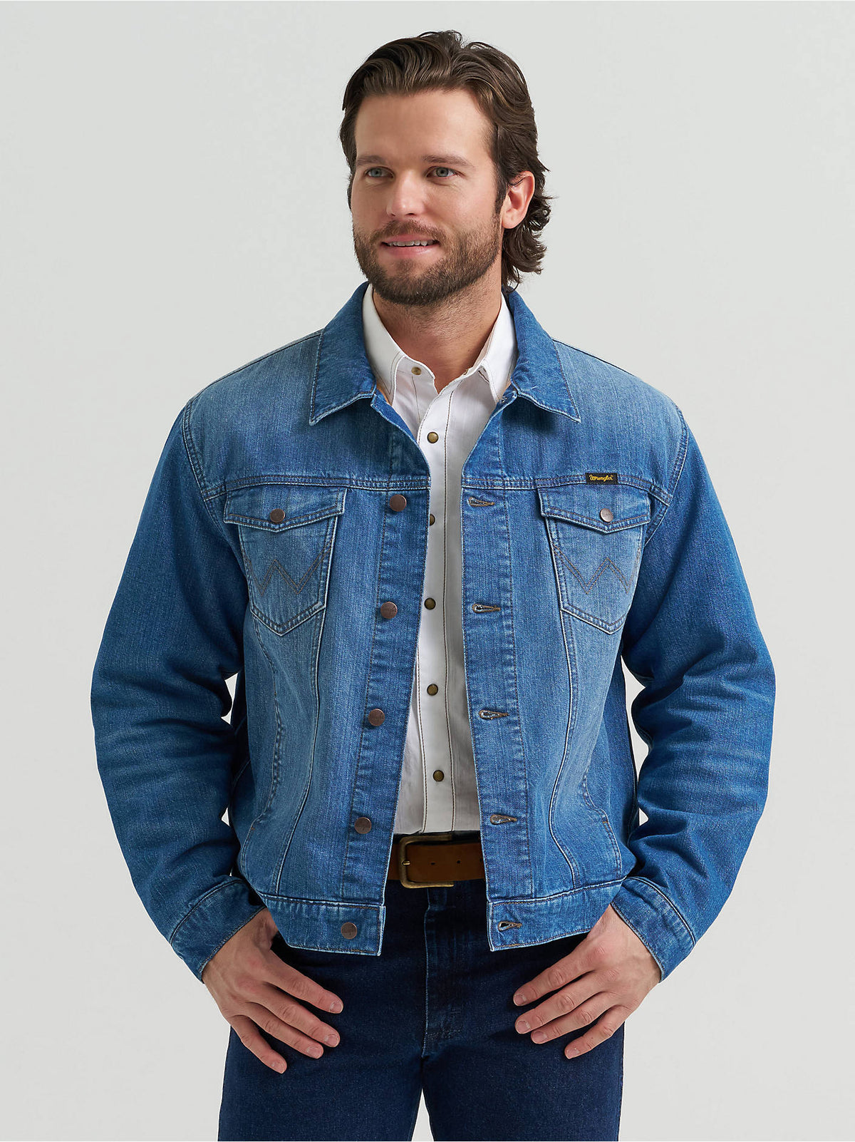 Man wearing the Wrangler® Cowboy Cut Flannel Lined Denim Jacket in Blue Indigo, a button-front denim trucker jacket.