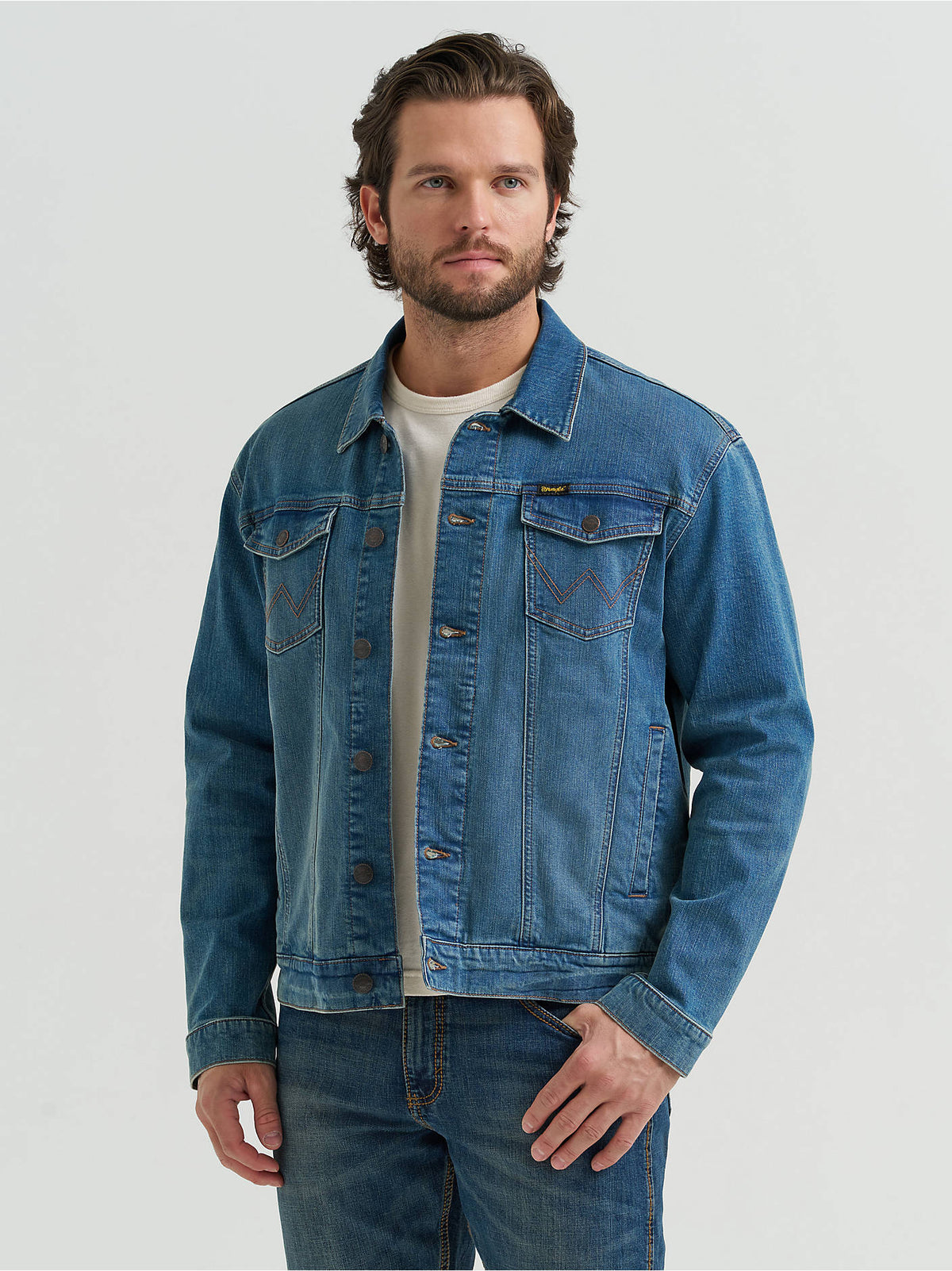 Man wearing the Wrangler Retro® Unlined Denim Jacket in Slate Blue, a stretch denim trucker jacket.